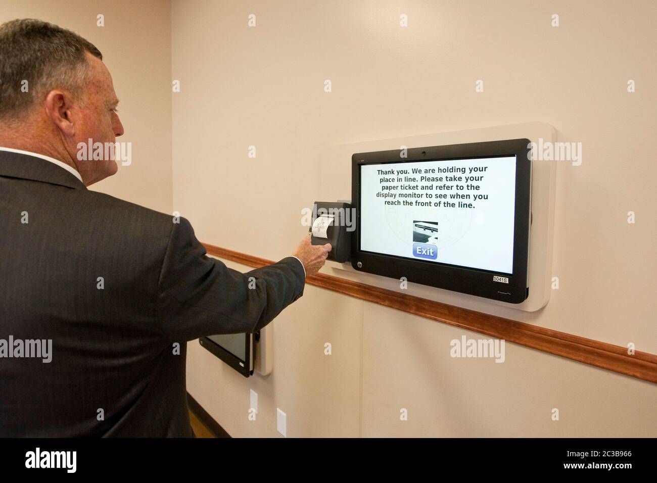 Pflugerville, Texas, USA, Oktober 2012: Der Kunde nutzt die Mobile Queue Management-Plattform, um im neuen MEGA-Center des US-amerikanischen US-Sicherheitsministeriums für Fahrerlaubnis einen Termin zu vereinbaren. Das QLess-Technologiesystem ermöglicht es Kunden, online oder telefonisch einer virtuellen Leitung beizutreten, sodass DPS-Mitarbeiter ihre Kunden schneller und effektiver bedienen können. ©MKC / Daemmrich Photos Stockfoto