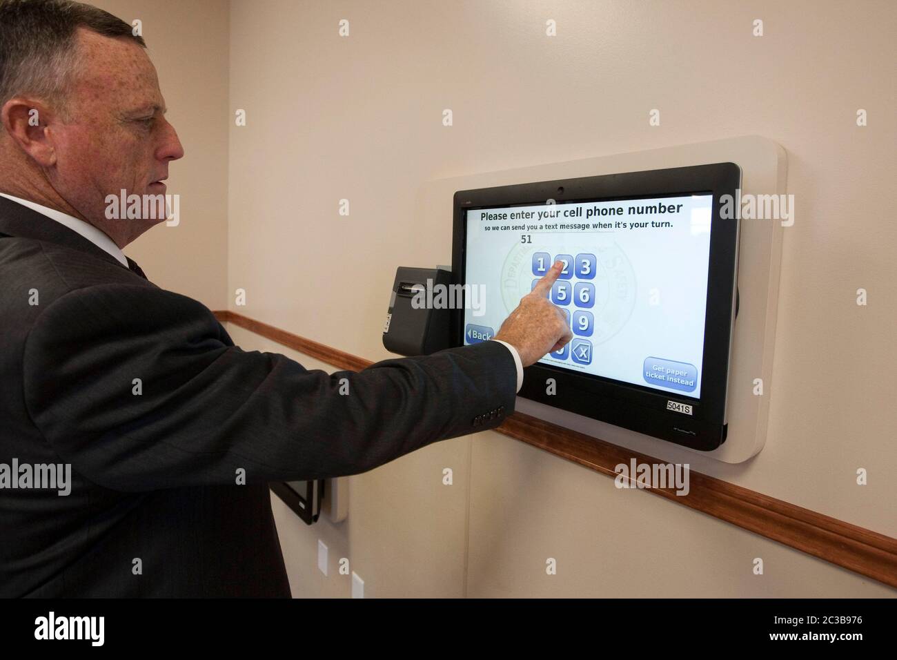 Pflugerville, Texas, USA, Oktober 2012: Der Kunde nutzt die Mobile Queue Management-Plattform, um im neuen MEGA-Center des US-amerikanischen US-Sicherheitsministeriums für Fahrerlaubnis einen Termin zu vereinbaren. Das QLess-Technologiesystem ermöglicht es Kunden, online oder telefonisch einer virtuellen Leitung beizutreten, sodass DPS-Mitarbeiter ihre Kunden schneller und effektiver bedienen können. ©MKC / Daemmrich Photos Stockfoto