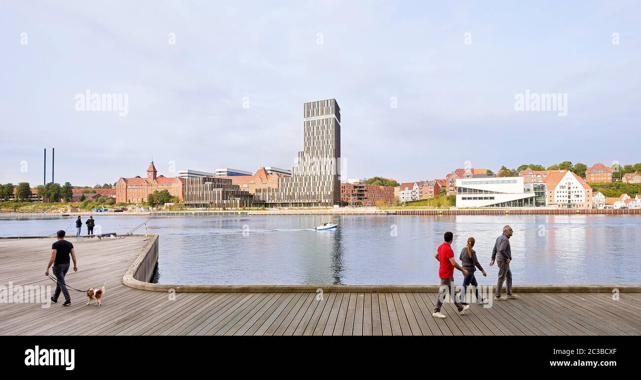 Kontextbezogene Ansicht des Hotel Alsik über den Fluss. Hotel Alsik, Sønderborg, Dänemark. Architekt: Henning Larsen, 2019. Stockfoto