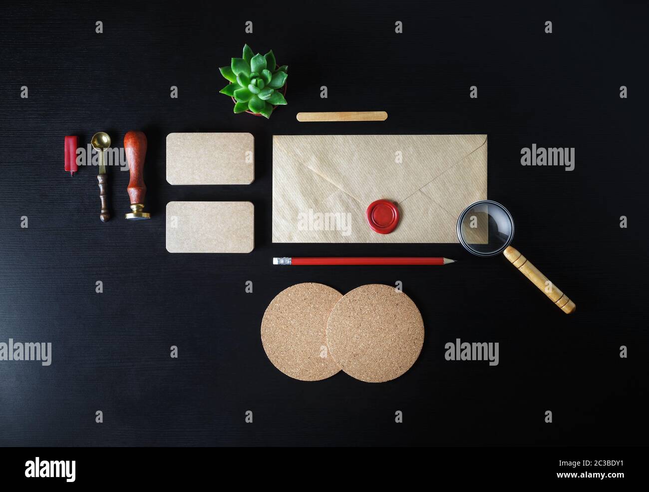Leere Kraftpapier Schreibwaren und corporate identity Vorlage auf schwarzem Holz- Hintergrund. Responsive Design mockup. Flach. Stockfoto