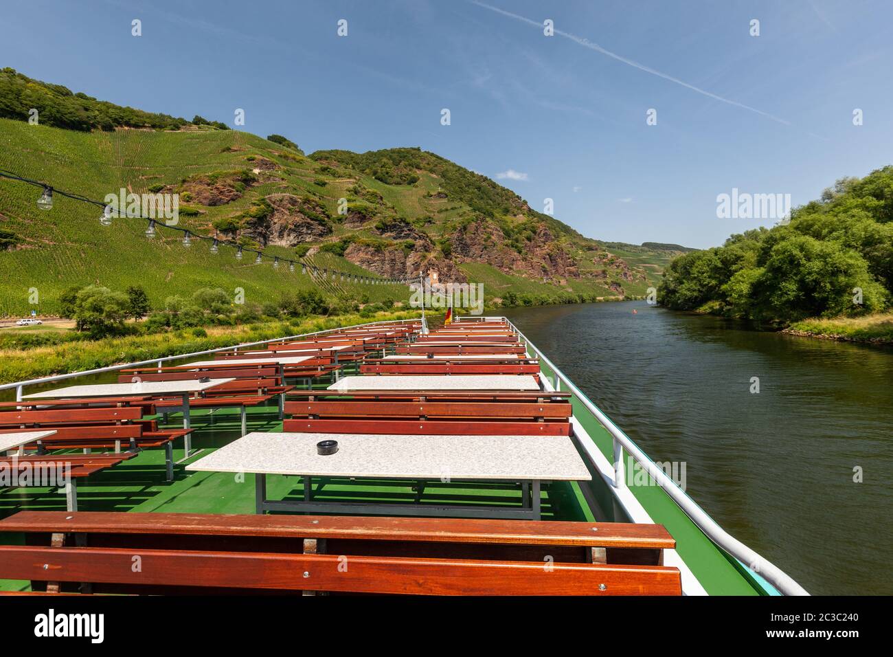 Passagierschiff auf der Mosel in der Nähe von Zeltingen-Rachtig und Berg mit Weinbergen und Schiefer Felsen im Hintergrund Stockfoto