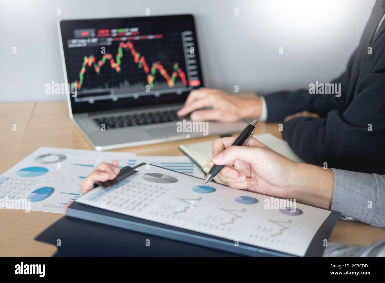 Die Unternehmer sprechen über Börse investieren Trading online Analyse ueber finanzielle Graph für Investitionszwecke Diskussion im Traders Büro Stockfoto