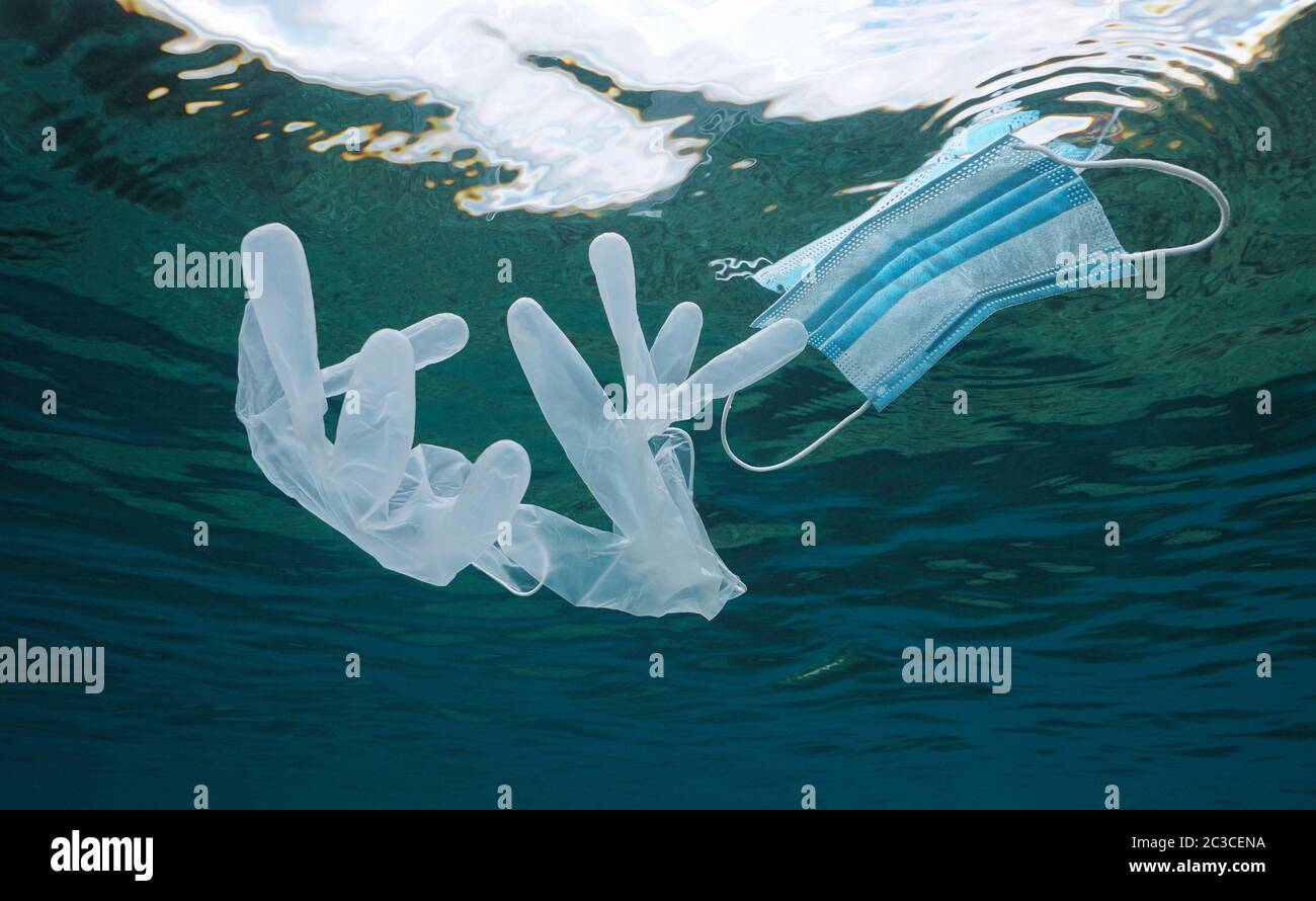 Gesichtsmaske und Handschuhe unter der Wasseroberfläche im Ozean, Plastikmüll Verschmutzung seit Coronavirus COVID-19 Pandemie Stockfoto