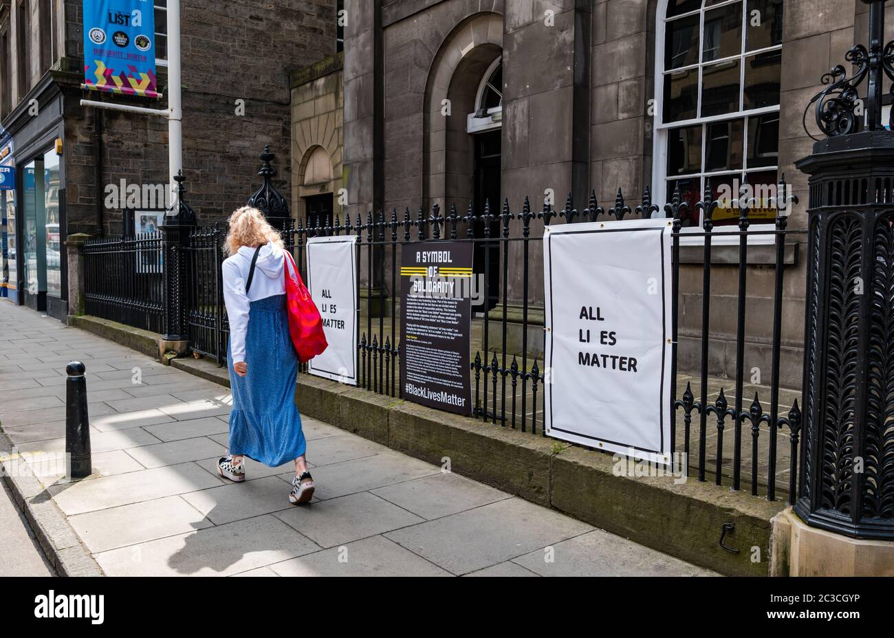 Edinburgh, Schottland, Großbritannien, 19. Juni 2020. Black Lives Matter Mural Trail: An Kunstorten entwickelt sich eine neue Spur von Kunstwerken, um die BLM-Kampagne zu unterstützen. Im Bild: Die Queen's Hall Konzerttheater Kunstwerk von Rudy Kanhye als eine Frau vorbeigeht Stockfoto