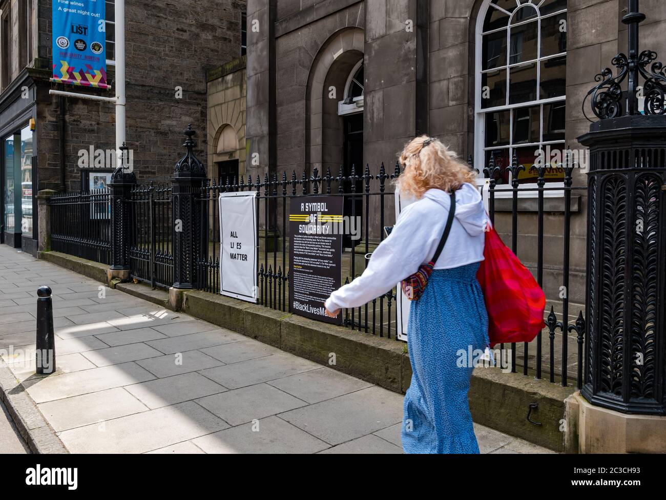 Edinburgh, Schottland, Großbritannien, 19. Juni 2020. Black Lives Matter Mural Trail: An Kunstorten entwickelt sich eine neue Spur von Kunstwerken, um die BLM-Kampagne zu unterstützen. Im Bild: Die Queen's Hall Konzerttheater Kunstwerk von Rudy Kanhye als eine Frau vorbeigeht Stockfoto