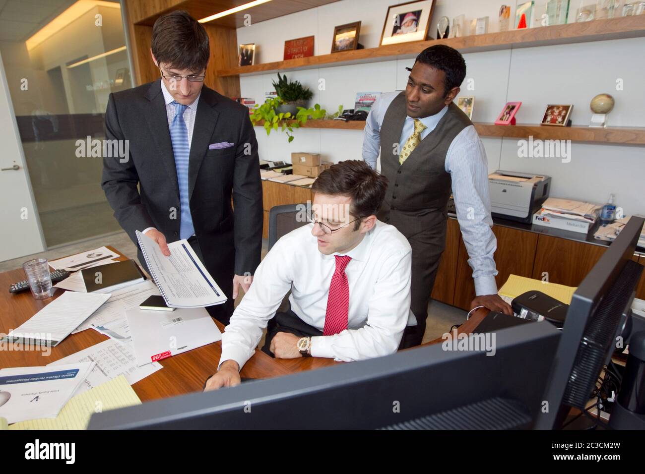 Austin Texas, USA, 2013: Gut gekleidete junge Geschäftsleute arbeiten zusammen an einem Projekt im Büro. ©Marjorie Kamys Cotera/Daemmrich Photography Stockfoto