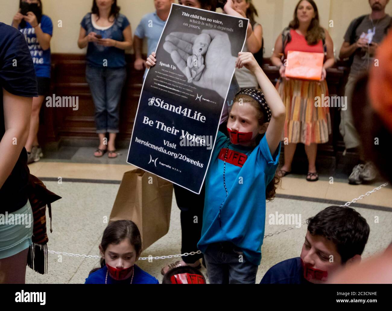 11. Juli 2013 Austin, Texas, USA: Menschenmassen für und gegen ein vorgeschlagenes neues Gesetz, das Abtreibungsbeschränkungen verschärfen würde, versammeln sich im Texas Capitol, während Senatoren über die umstrittenen Gesetze debattieren. Dieses junge Mädchen hat ein Poster, auf dem ein kleiner menschlicher Fötus zu sehen ist. ©Marjorie Kamys Cotera/Daemmrich Photography Stockfoto