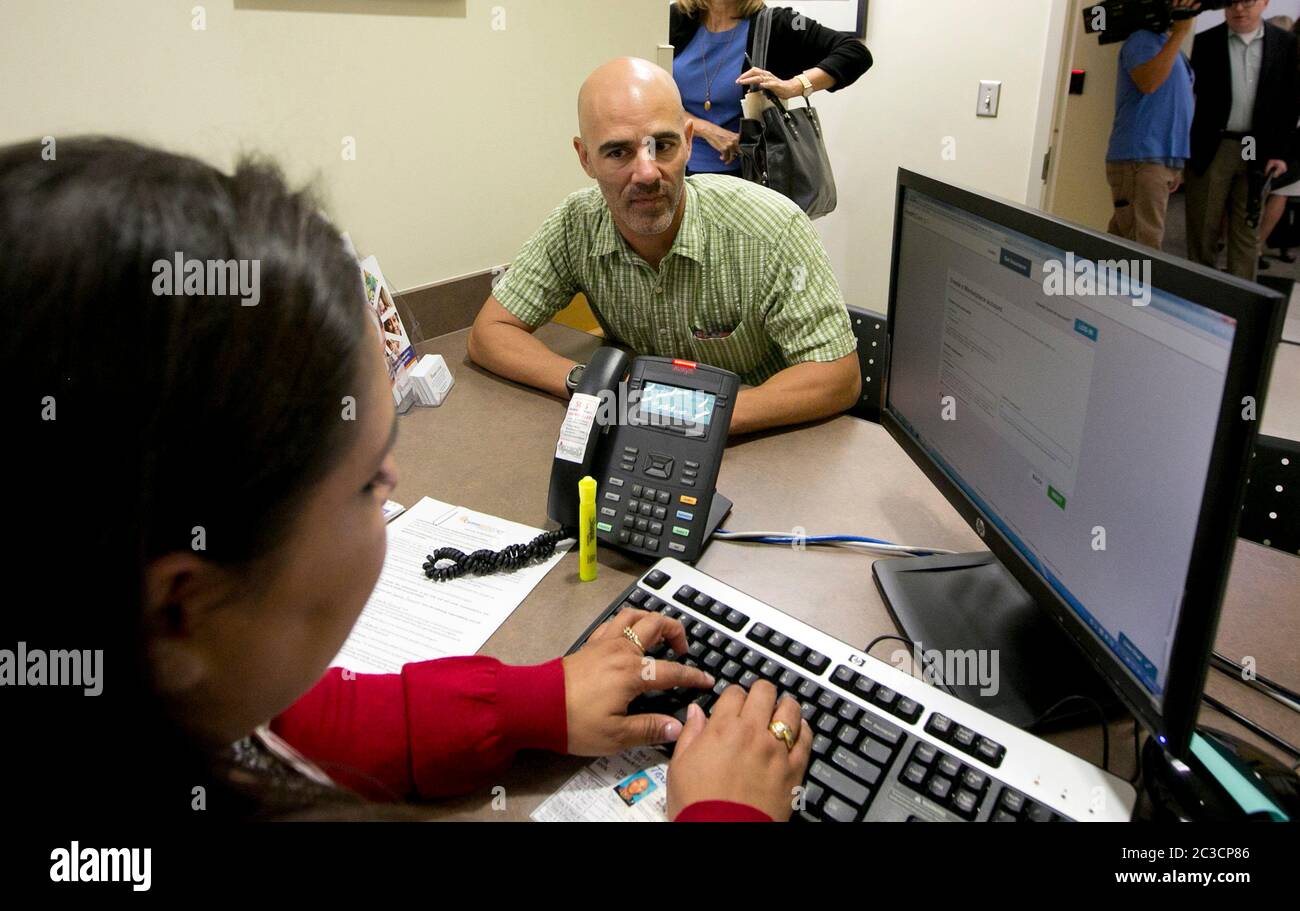 Austin Texas USA, Oktober 25 2013: Healthcare, Website Obamacare, Versicherung - Patient Navigator an der CommUnityCare Public Health Care Clinic hilft dem Kunden, die Optionen der Krankenversicherung auf der HealthCare.gov Website zu überprüfen, um die Abdeckung unter dem Affordable Care Act (Obamacare) zu sichern. ©Marjorie Kamys Cotera/Daemmrich Stockfoto