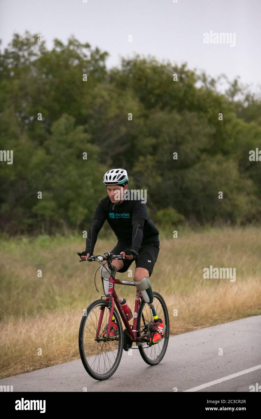 Carlos Gutierrez, ein Geschäftsmann aus dem nördlichen Bundesstaat Chihuahua in Mexiko, ließ sich 2011 in seinem Heimatland von Gangstern die Füße abschlagen. Er überlebte, floh aus seiner Heimat, kam mit seiner Familie in die USA und beantragte politisches Asyl. Als Teil seiner Therapie und zur Sensibilisierung für Gewalt in Mexiko fährt er mit dem Fahrrad von El Paso, Texas, nach Austin. Carlos ist Mitglied der in El Paso ansässigen gemeinnützigen Gruppe „Mexikaner im Exil“. ©Marjorie Kamys Cotera/Daemmrich Photography Stockfoto