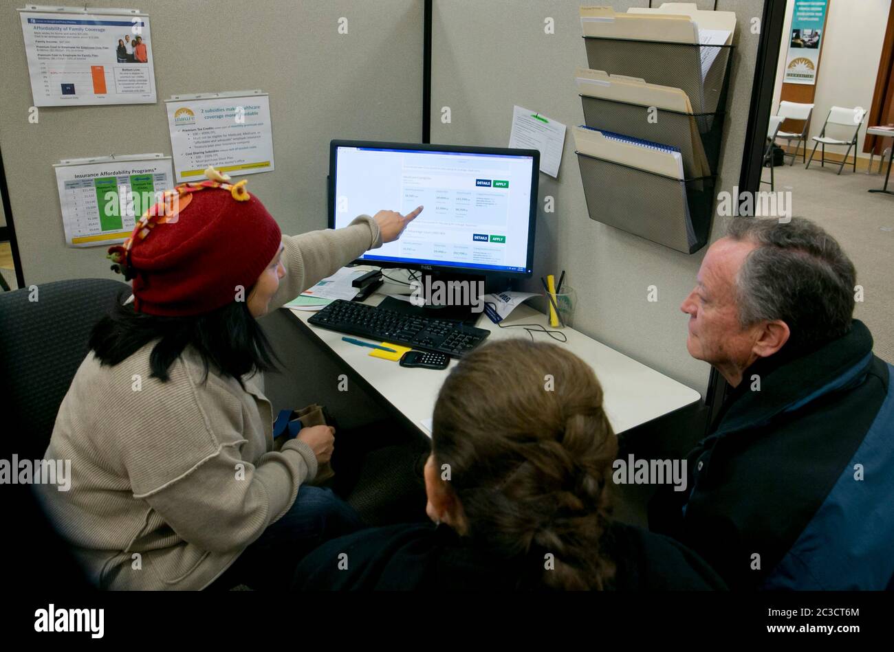 Austin, Texas, USA, Dezember 5 2013: Ein Freiwilliger mit einer gemeinnützigen Organisation hilft einem einkommensschwachen Paar, sich im Rahmen des Affordable Care Act in einem Einkaufszentrum für eine Krankenversicherung zu registrieren. ©Marjorie Kamys Cotera/Daemmrich Photography Stockfoto