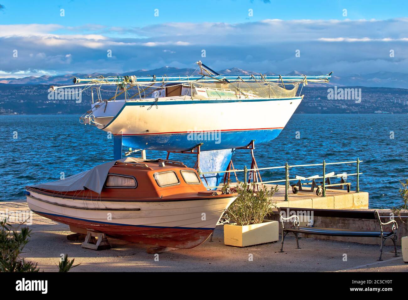 Segelboot und kleines Boot auf Trockendock am Meer Stockfoto