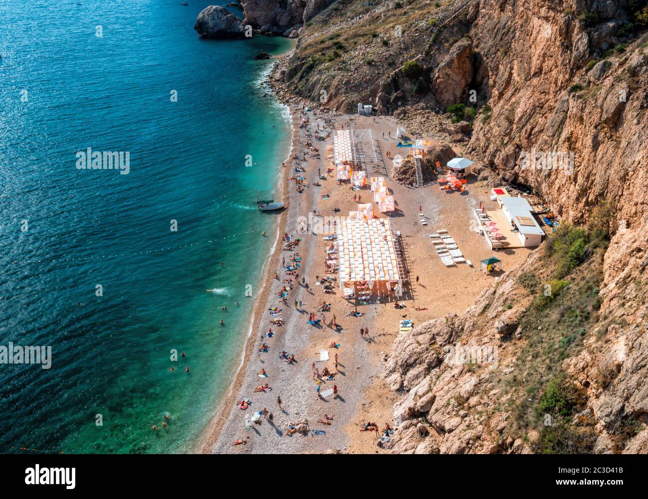 Felsiger Strand mit rosa Kieselsteinen und kristallklarem azurblauem Meer. Konzept der Reise, idealer Ort für Sommerurlaub am Meer in einem sicheren Ort. Speicherplatz kopieren Stockfoto