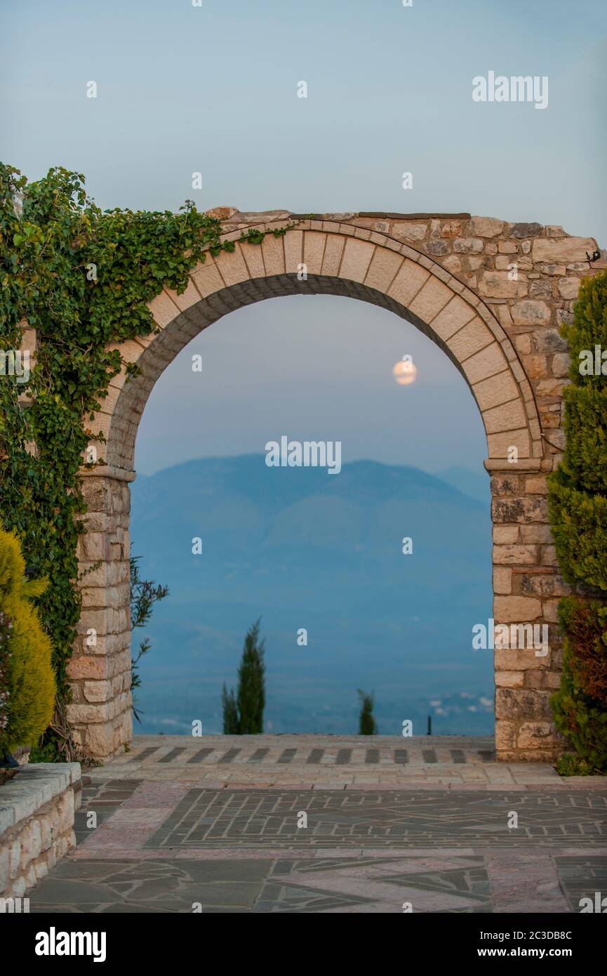 Blick auf den aufgehenden Vollmond durch ein altes Tor in Saranda, ist eine Küstenstadt in Albanien. Stockfoto