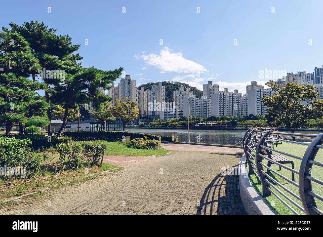 Bergab gepflasterter Weg zum Kanal mit Fahrradweg und Stadtbild von Busan Blick Stockfoto