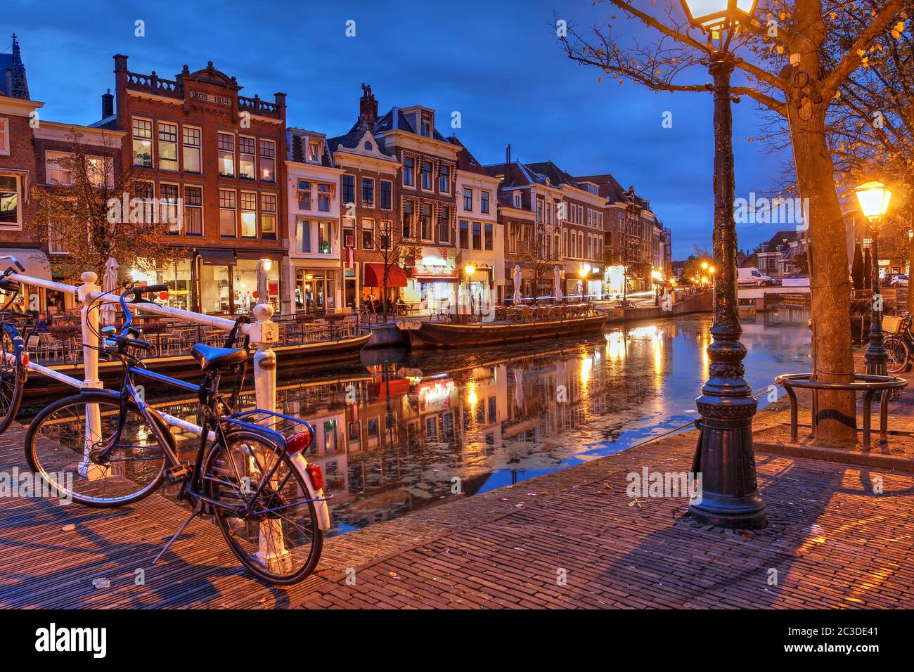 Nachtszene in Leiden, Niederlande mit alten Häusern am Nieuwe Rijn Kanal. Stockfoto