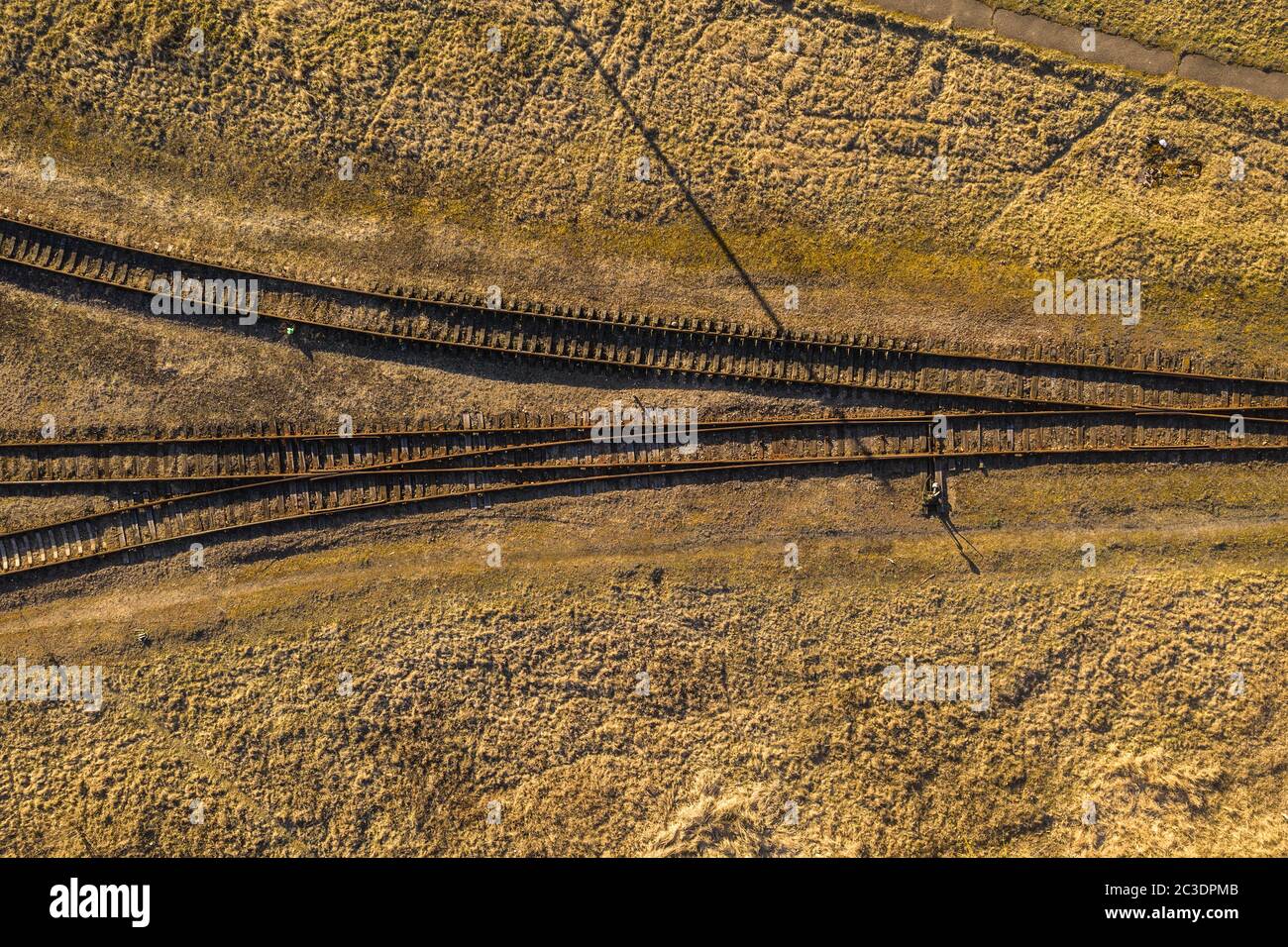 Drohnenfotografie von alten rostigen Eisenbahnkreuzung während des Sommertages. Stockfoto