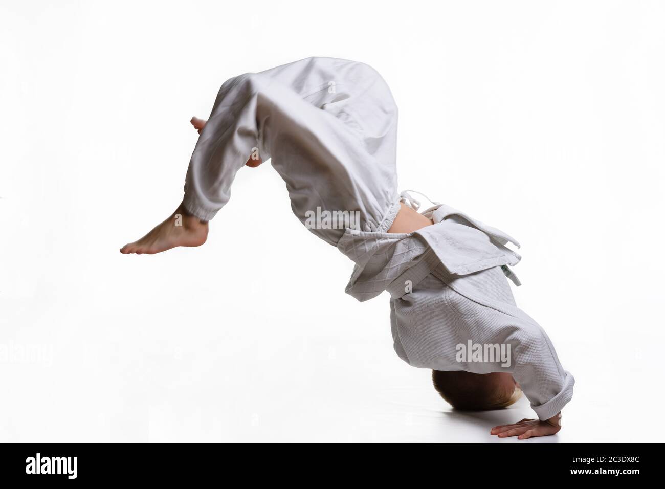 Judo-Junge in weißem Kimono tuend sommersault Stockfoto