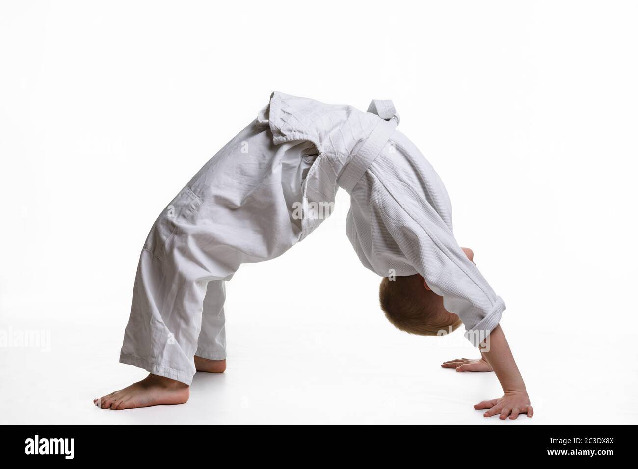 Junge Athletin macht beim Aufwärmen der Judo-Sektion eine Brücke Stockfoto