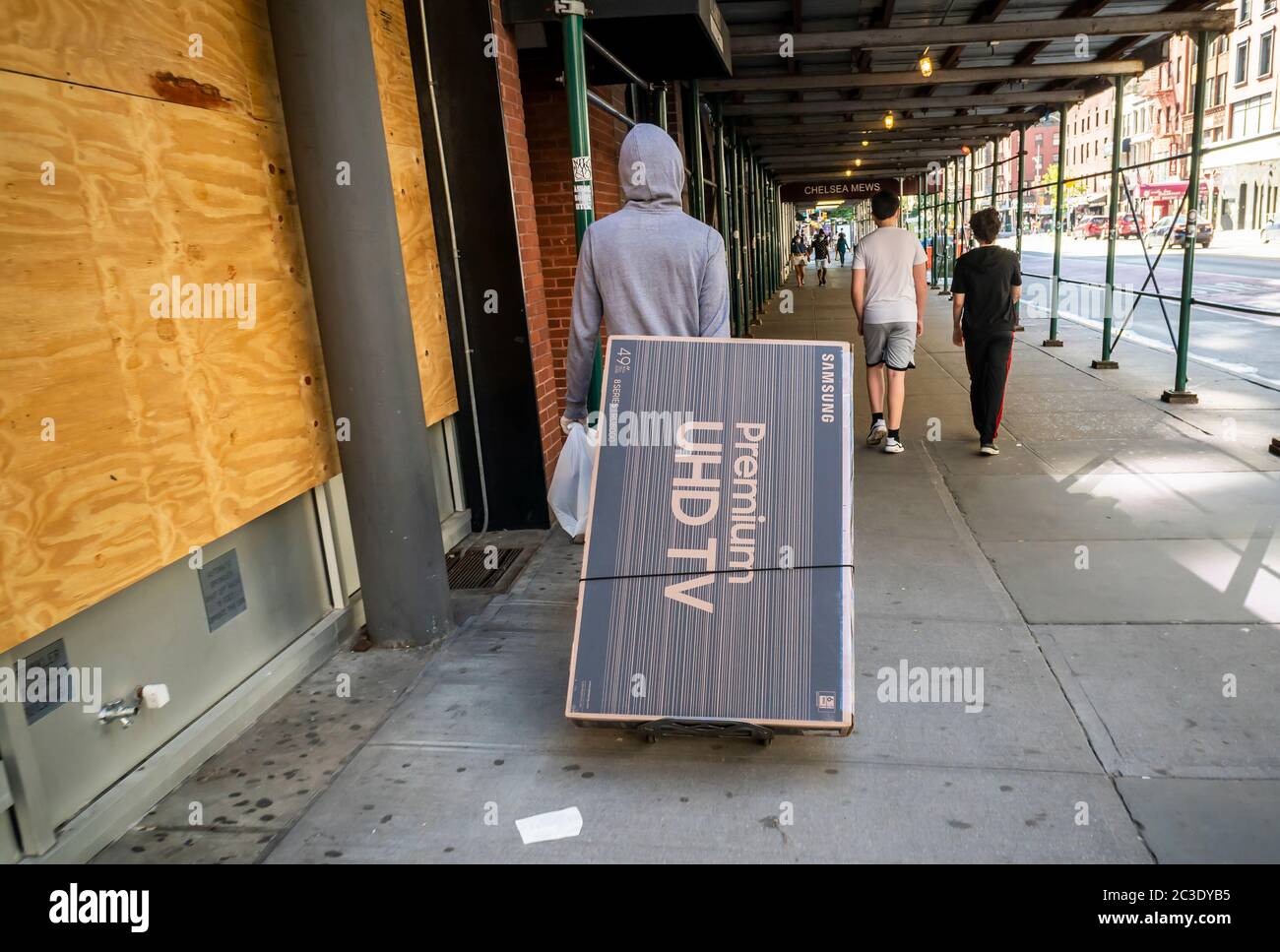 Der Kunde trägt seine Marke Samsung Flachbildschirm-Fernseher in Chelsea in New York am Samstag, 13. Juni 2020 als Geschäfte für Bordkügelabholung während Phase eins der Stadt Wiedereröffnung geöffnet. (© Richard B. Levine) Stockfoto