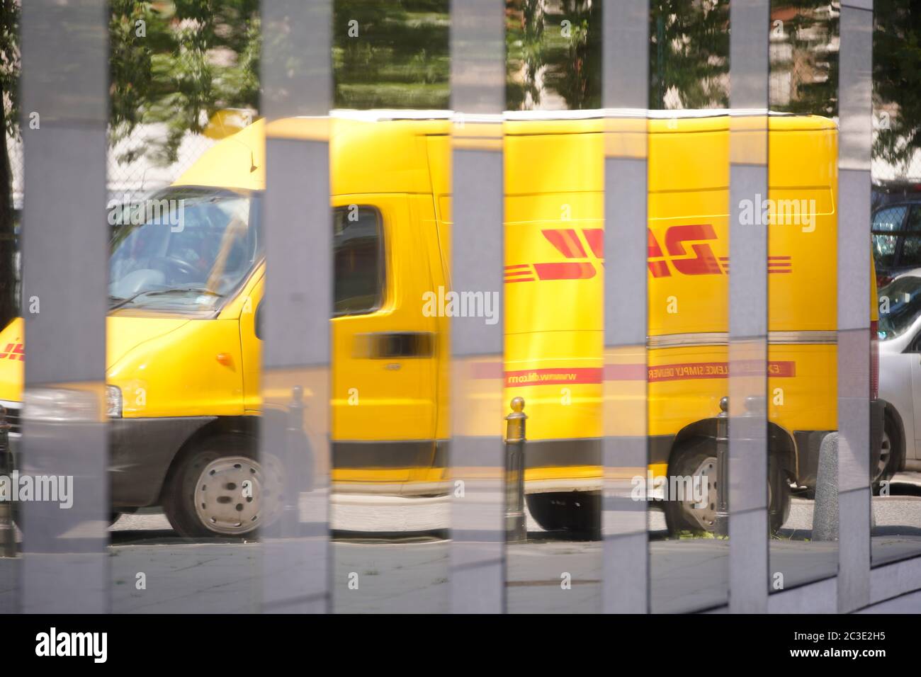Ein DHL-Lieferwagen spiegelt sich am 19. Juni 2020 in Warschau, Polen, in den Fenstern eines Geschäftsgebäudes wider. Stockfoto