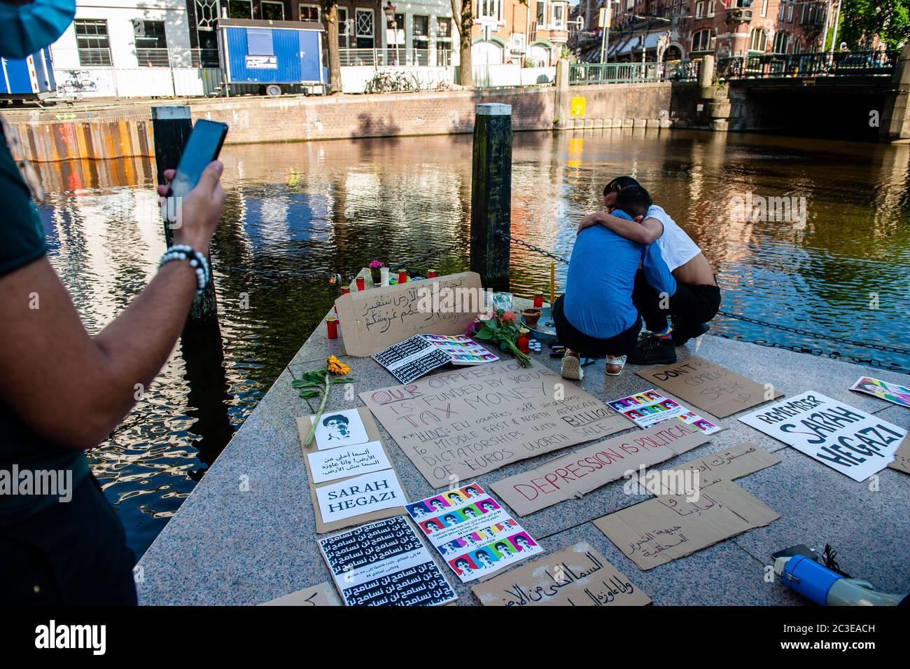 Ein Paar Männer hielten sich während des Gedenkens gegenseitig in der Hand und weinten.um das Homomonument (ein Denkmal, das an alle Schwulen und Lesben erinnert, die wegen ihrer Homosexualität verfolgt wurden) versammelten sich die Menschen, um das Leben und die Tapferkeit von Sarah Hegazi zu ehren und zu feiern, Eine ägyptische queere kommunistische Aktivistin, die am 14. Juni 2020 durch Selbstmord starb, nachdem sie vom Sissi-Regime brutal und gewaltsam inhaftiert worden war. Sie wurde eingesperrt, nachdem sie beim Maschrou Leïla Konzert 2017 eine Regenbogenfahne wedeln ließ. Stockfoto