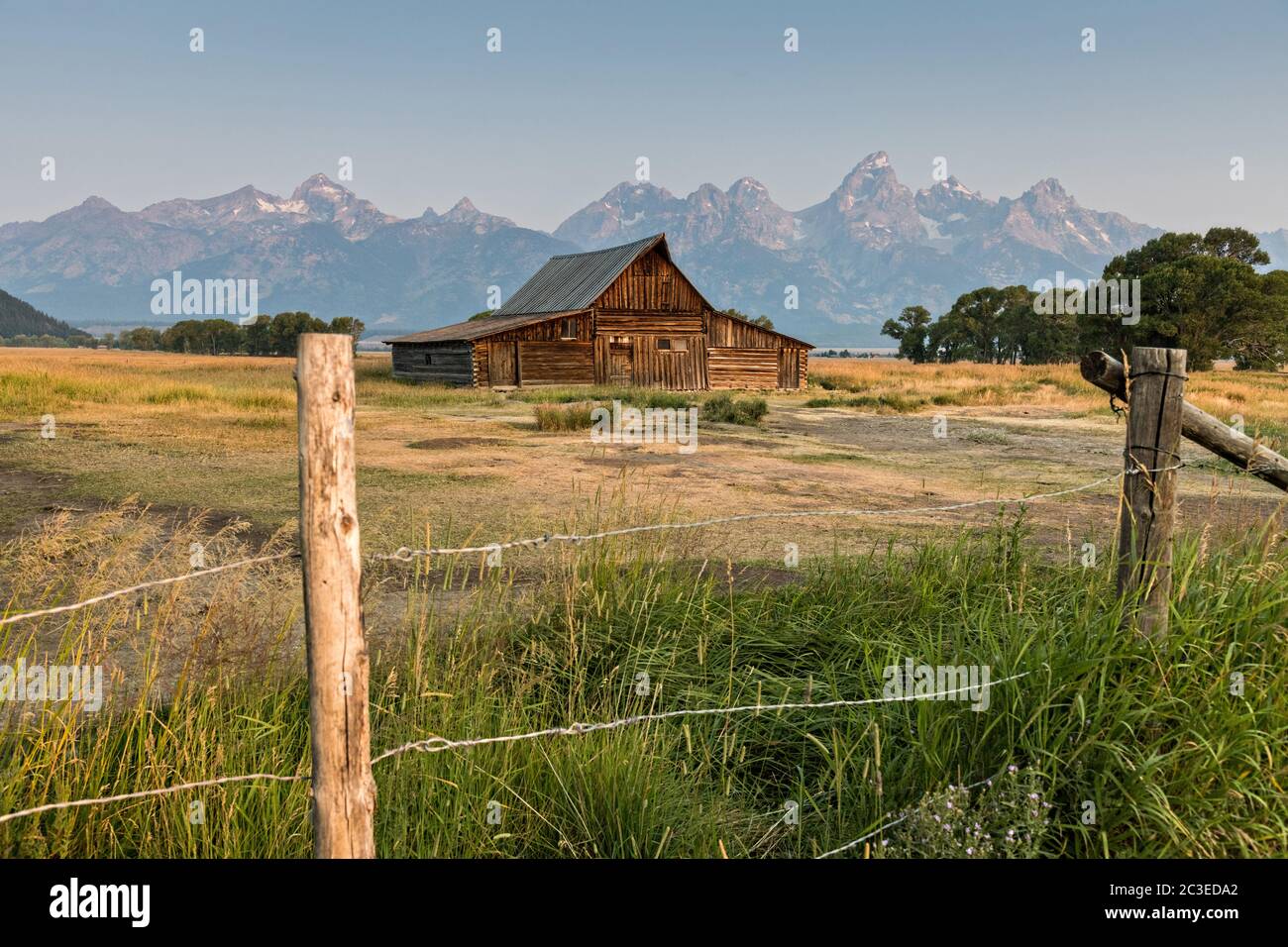 Morgensonnenaufgang über der T.A Molton Scheune im Mormon Row Historic District entlang der Antelope Flats mit den Grand Teton Bergen hinter dem Grand Teton National Park, Wyoming. Stockfoto