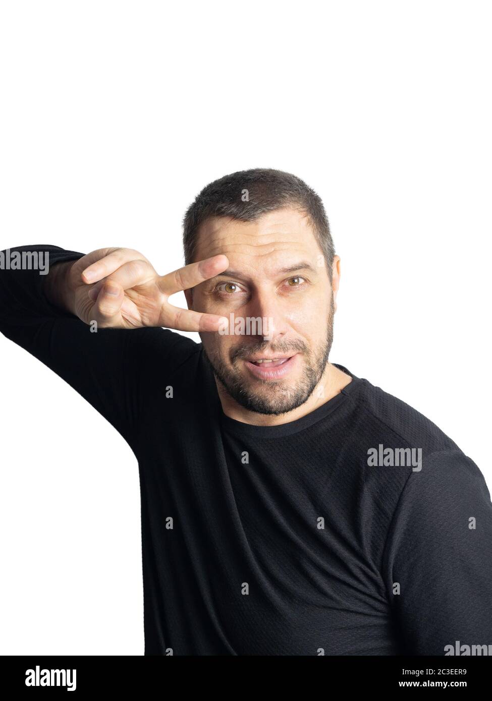 Ein Mann mit einem Bart in einer schwarzen Jacke hält zwei Finger in der Nähe seines Gesichts auf einem isolierten Hintergrund Stockfoto