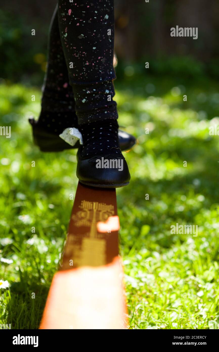 Junges Mädchen zu Fuß auf Slackline im Stadtpark. Stockfoto