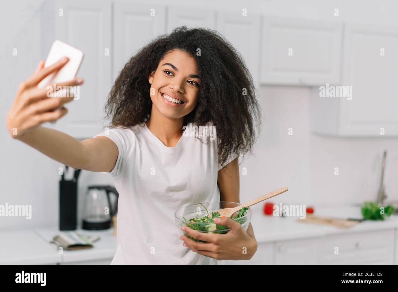 Schöne afroamerikanische Lebensmittel Blogger Kochen vegetarisches Abendessen in der Küche, Streaming-Video online. Gesundes Lifestyle-Konzept Stockfoto