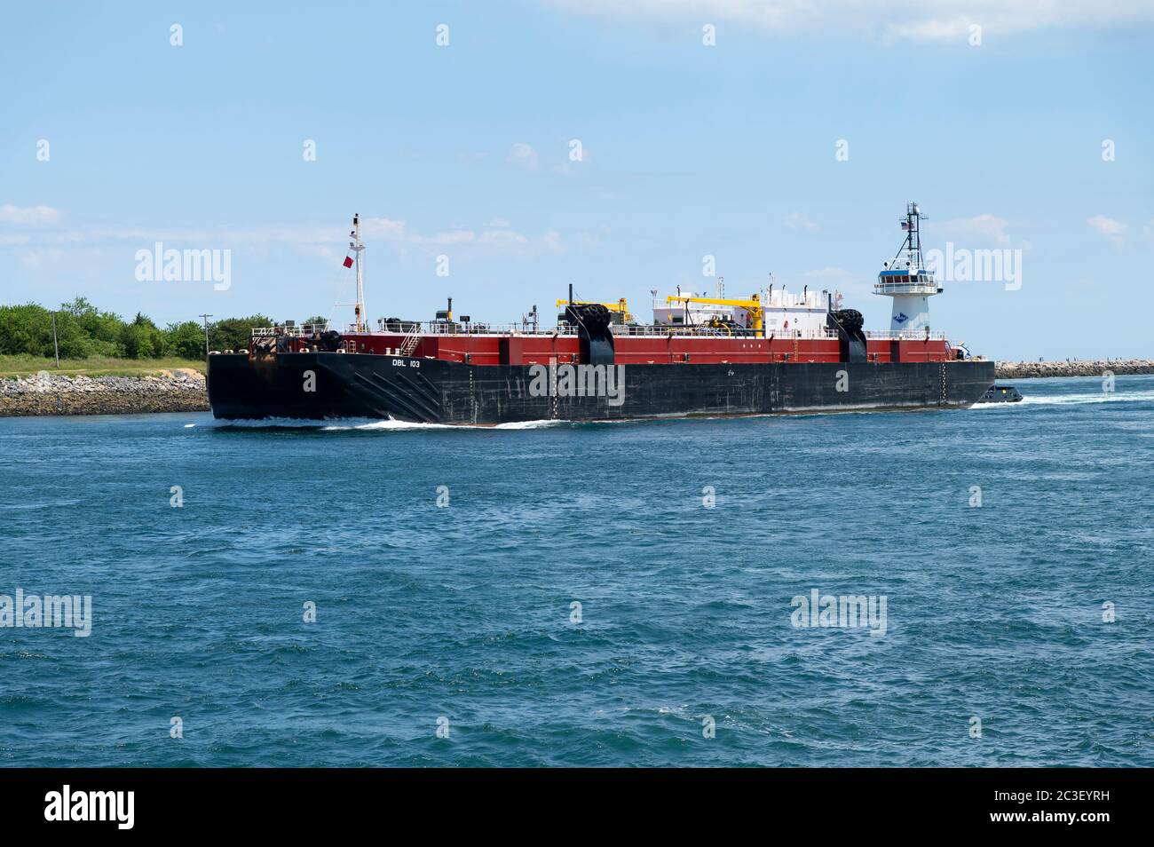 Ein Containerschiff und Schlepper unterwegs im Cape Cod Canal, in Sandwich, Massachusetts, USA Stockfoto