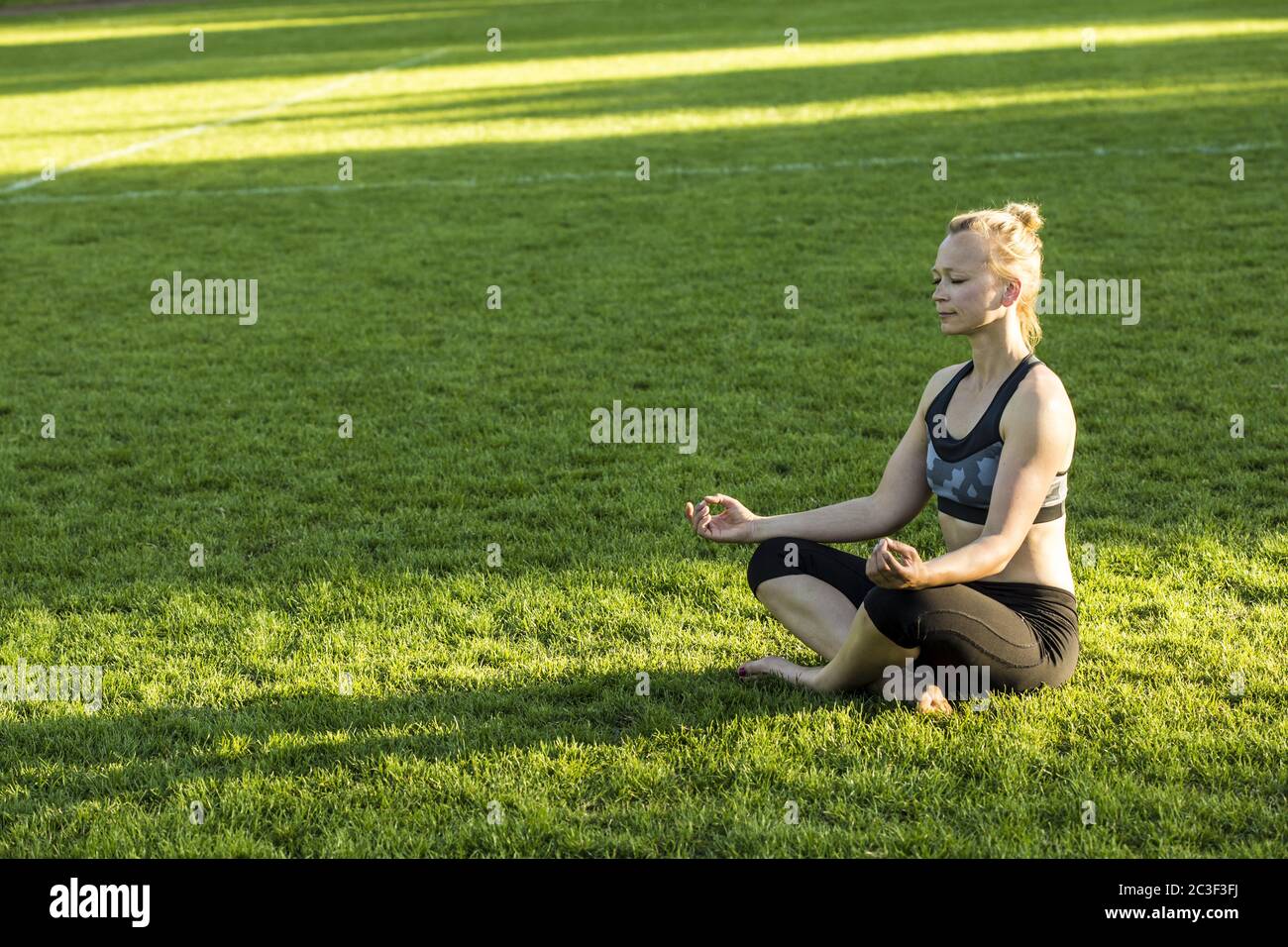 Frau (38) beim Yoga auf einer Wiese im Park, Kiel, Schleswig-Holstein, Deutschland Stockfoto