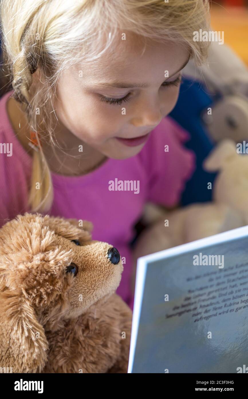 Mädchen (7) liest in einem Buch, Kiel, Deutschland Stockfoto