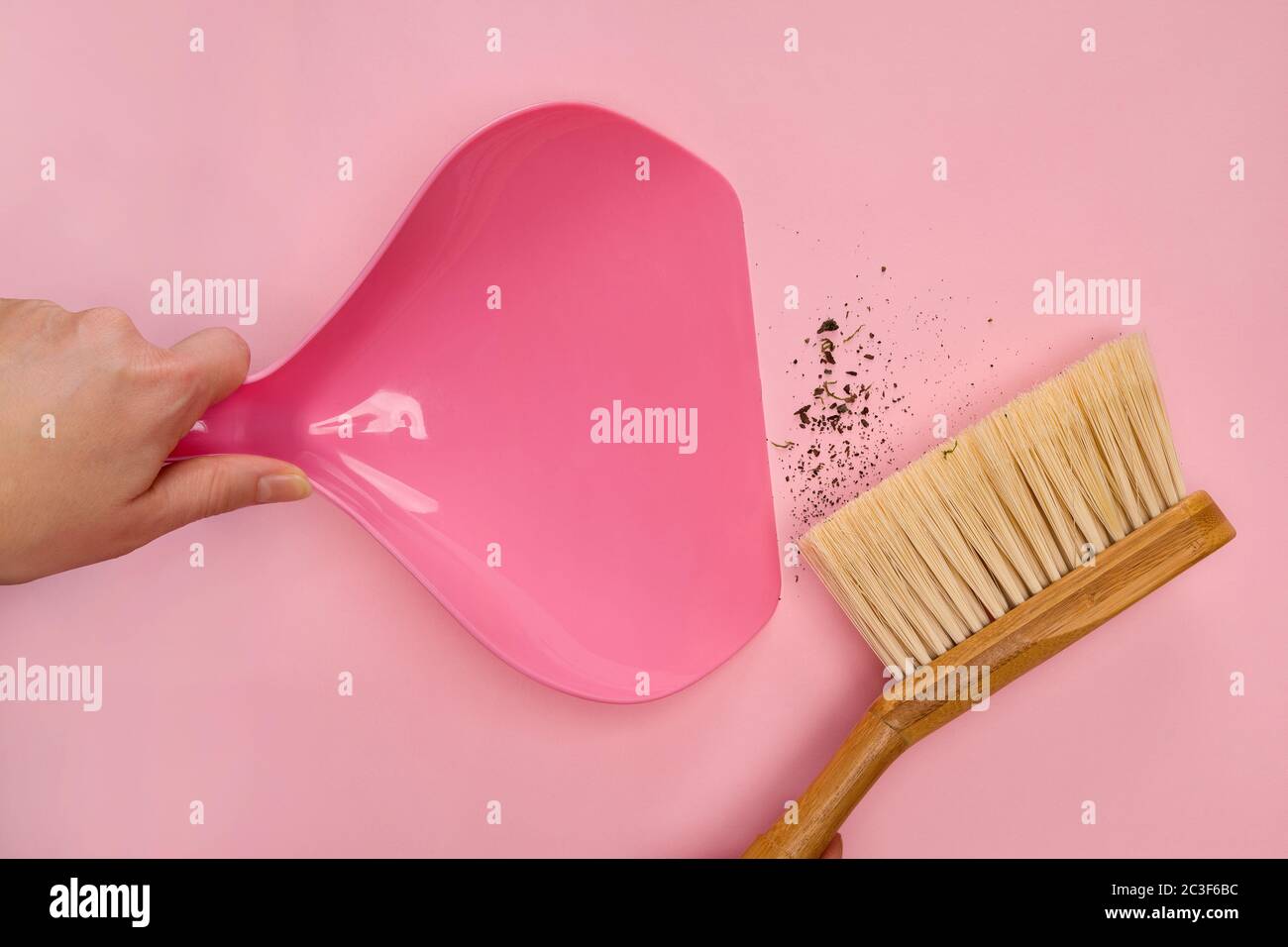 Frau mit Holzbeesen und Kehrschaufel fegen schmutzigen Boden. Stockfoto