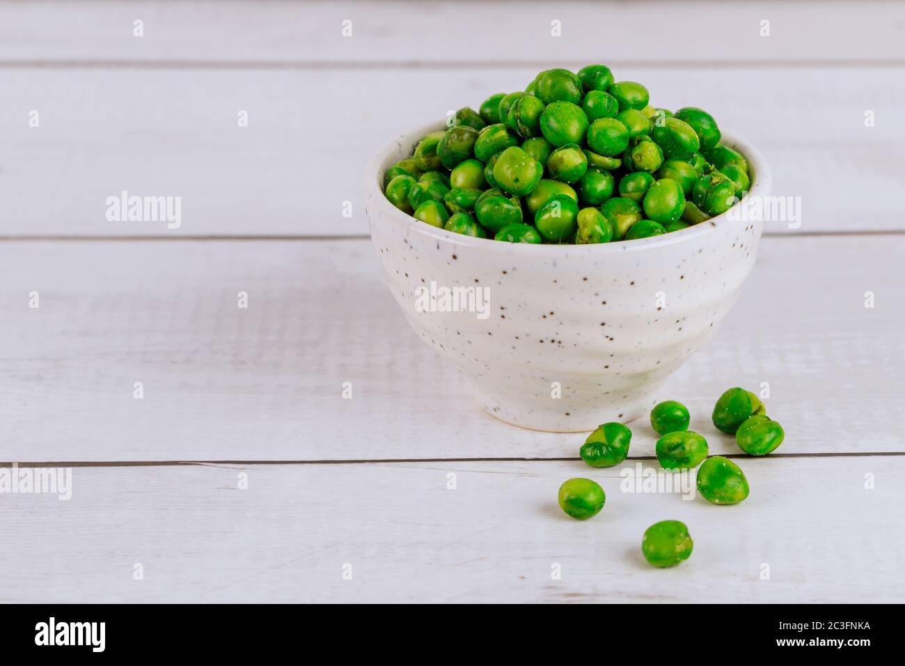 Knusprig gebratene, gesalzene grüne Erbse in einer weißen Schüssel. Stockfoto