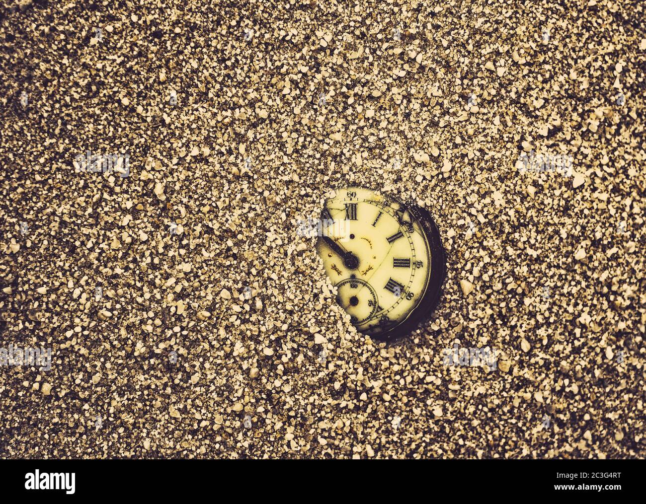 Der Sand der Zeit. Antike verfaulte Taschenuhr teilweise im Sand begraben Stockfoto