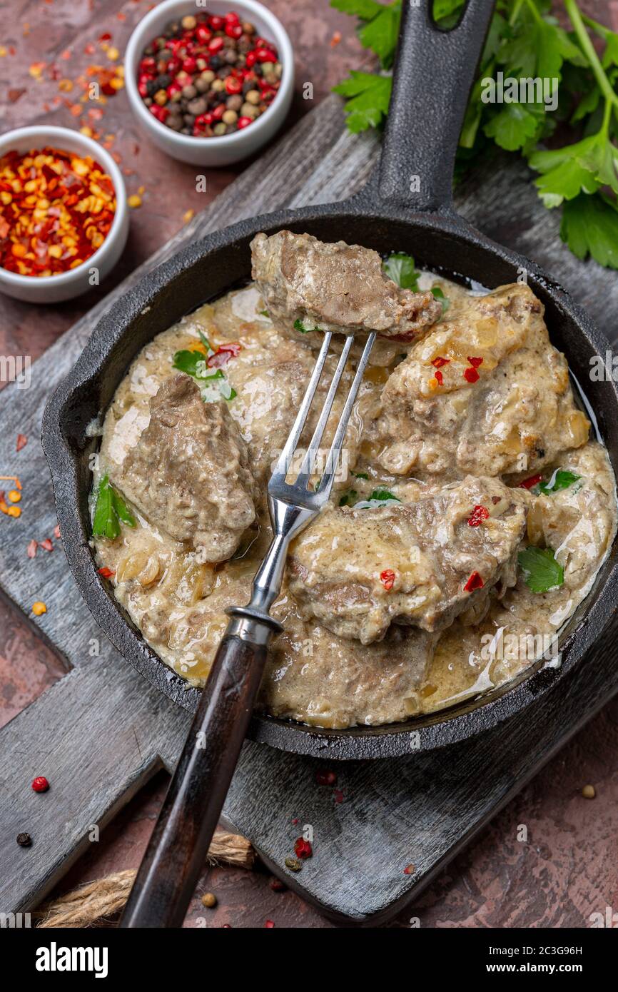 Leber in saurer Sahne mit Chilischoten und Petersilie geschmort. Stockfoto