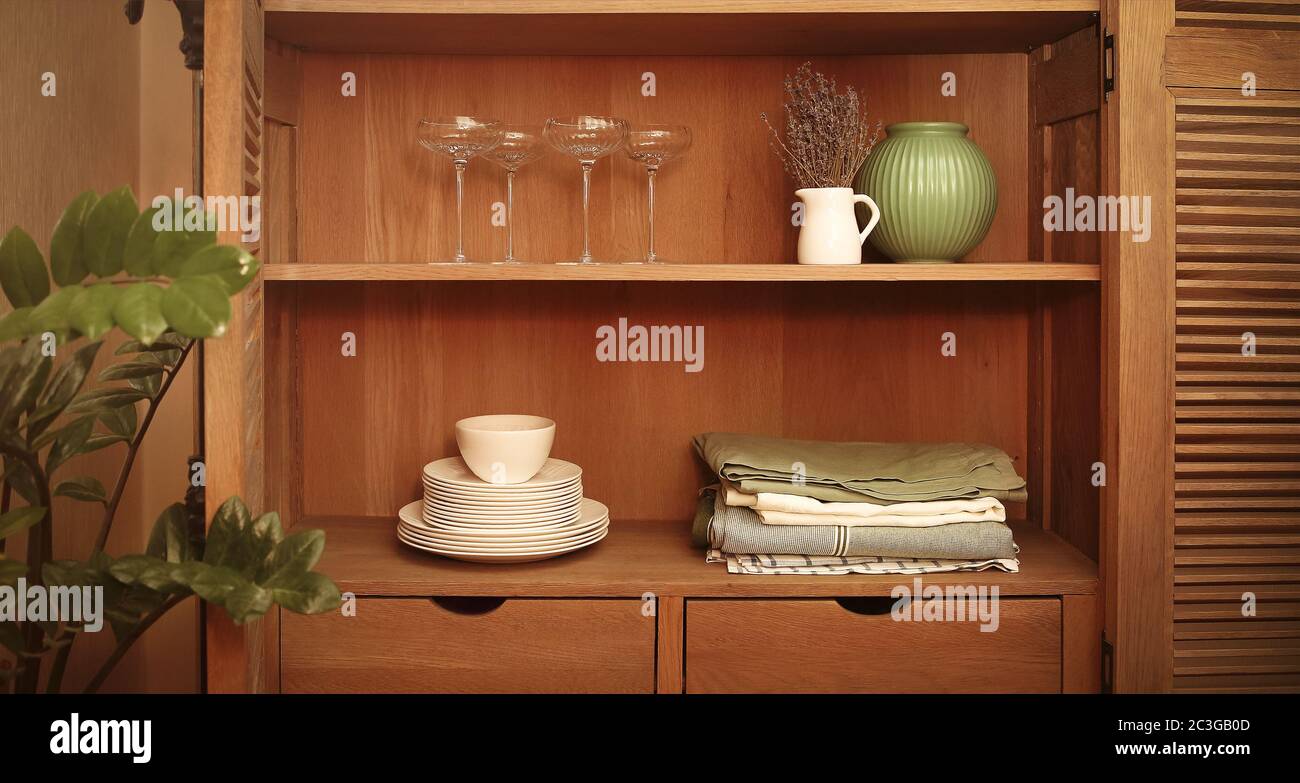 Schrank im Retro-Stil mit Tellern, Tischdecken, Vasen und Gläsern Stockfoto