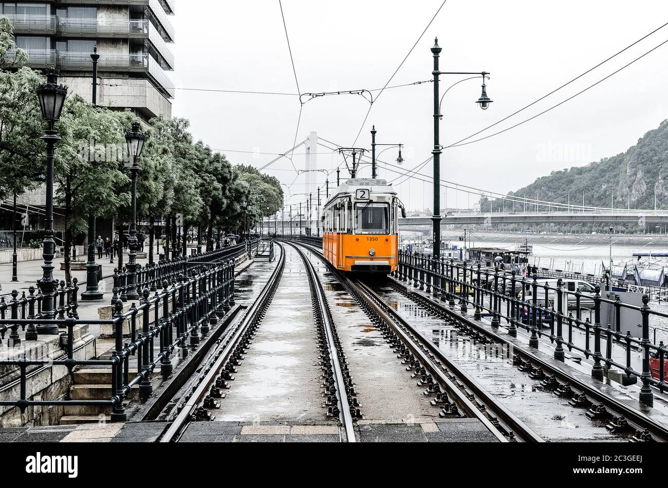 Die orangefarbene Straßenbahn Nummer 2 führt von der Erzhebet-Brücke in der Nähe des Belgrader Embankment entlang der Donau. Budapest, Ungarn Stockfoto