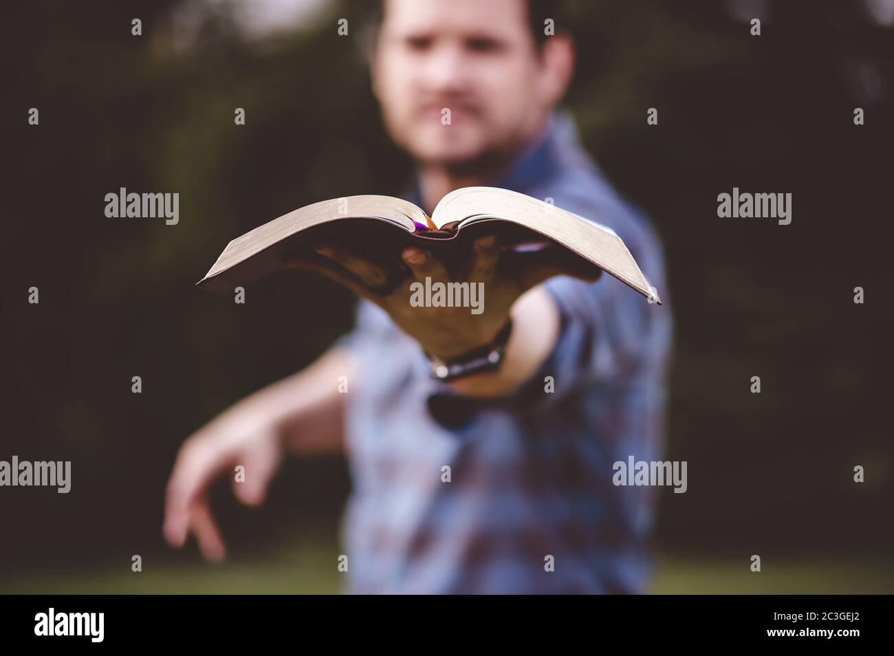 Mann hält die Heilige Bibel und predigt sie mit einem Viel Enthusiasmus Stockfoto