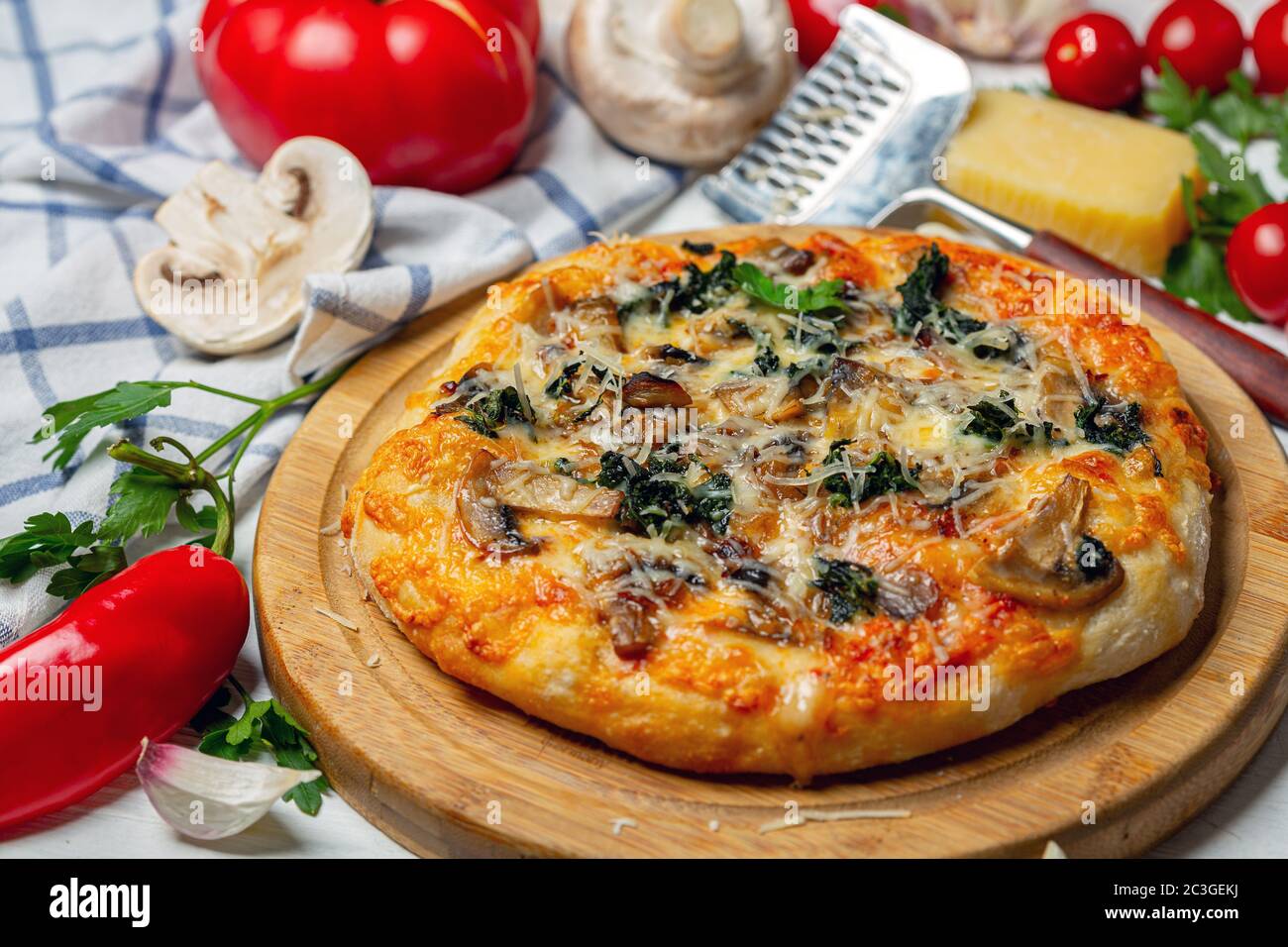 Hausgemachte Pizza mit Mozzarella, Pilzen und Spinat. Stockfoto