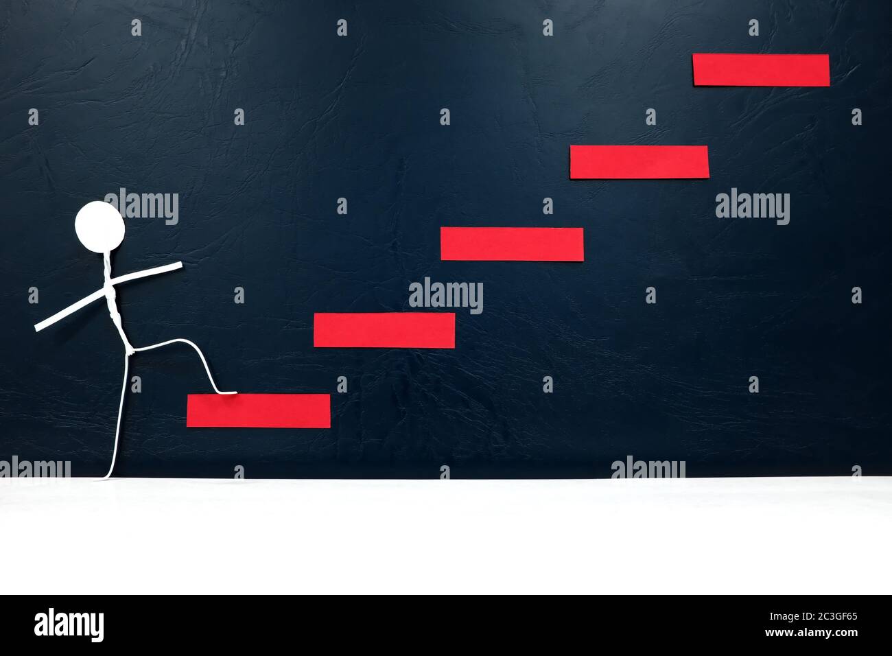 Leiter zum Erfolg Konzept. Menschliche Stockfigur, die ersten Schritt auf einer roten Treppe. Stockfoto