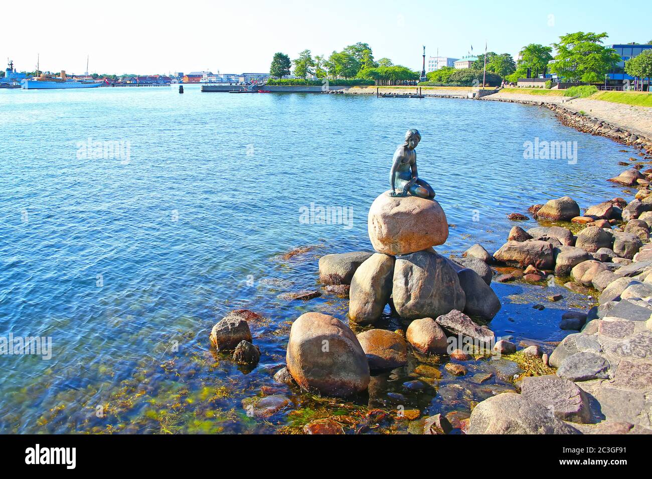 Langelinie Promenade mit der ikonischen kleinen Meerjungfrau Statue & Wahrzeichen im Vordergrund und der Hafen im Hintergrund, Kopenhagen, Dänemark. Stockfoto
