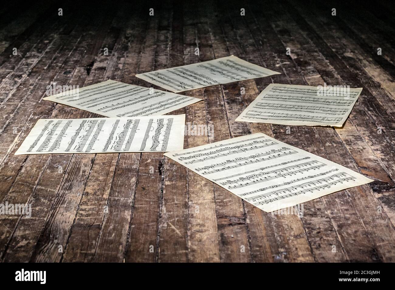 Musikblätter mit Noten eines Musikwerks liegen im Dunkeln auf dem alten Boden Stockfoto
