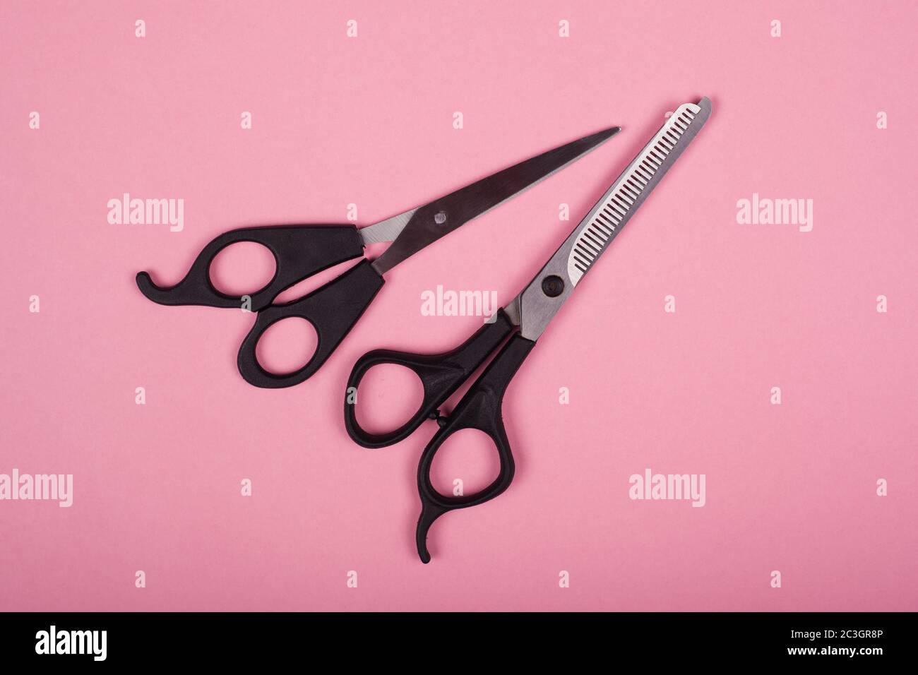 Schere für Haarschnitte auf rosa Hintergrund Stockfoto