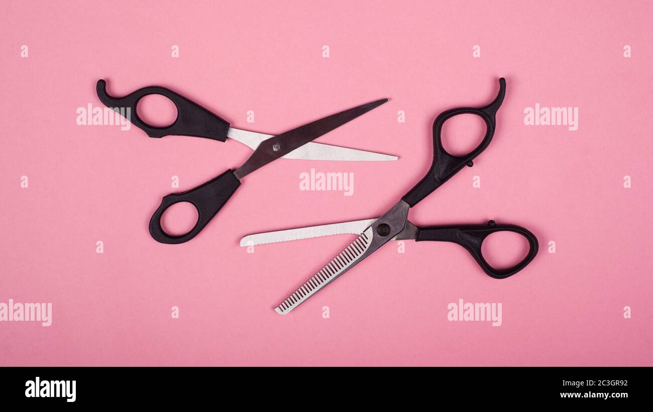 Zwei Scheren für Haarschnitte auf rosa Hintergrund. Stockfoto
