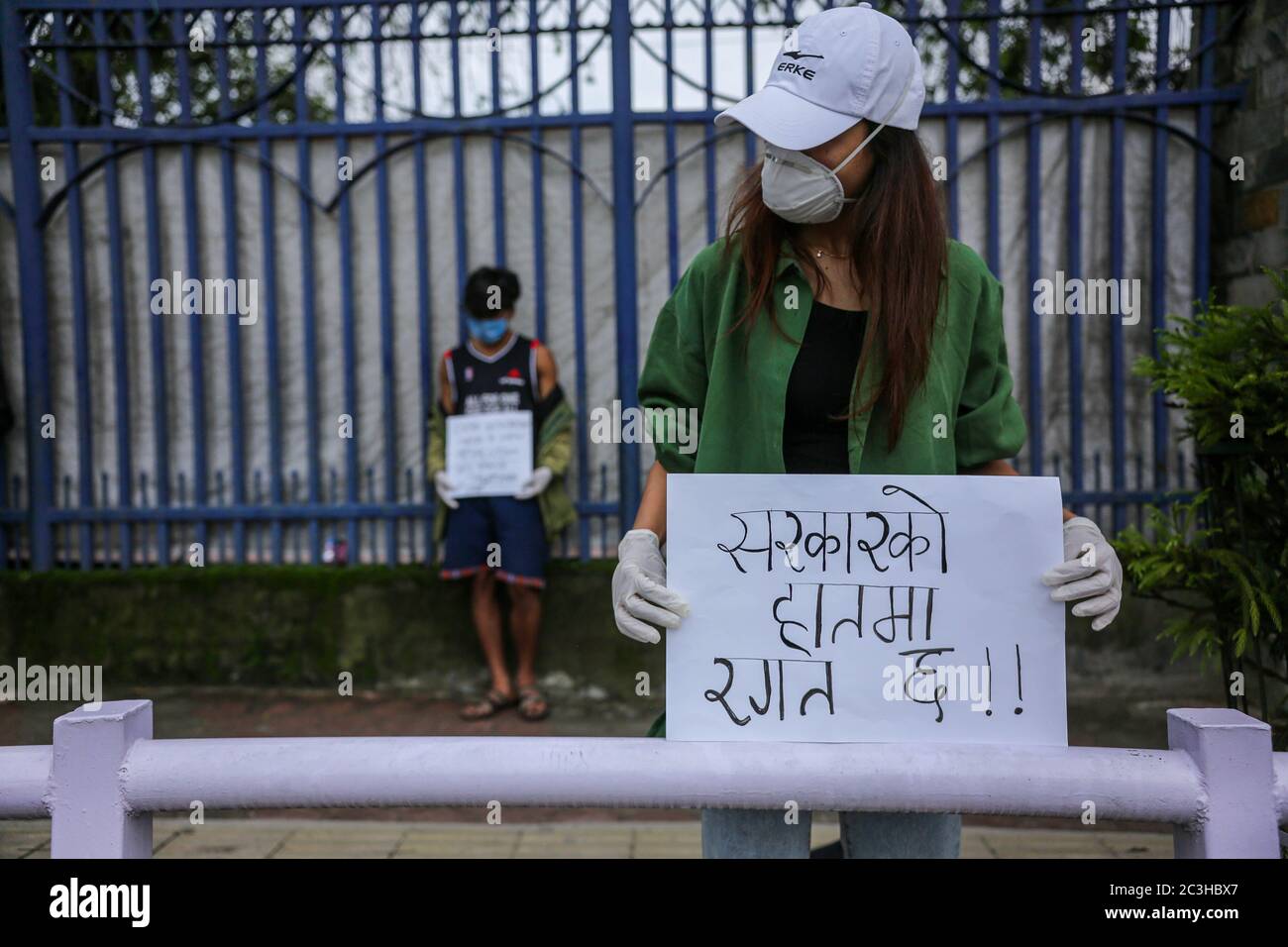 Eine junge Frau mit Gesichtsbefrass wird während des Protestes mit einem Plakat gesehen. Jugend inszenieren einen Protest als Symbol gegen das Missmanagement der Regierung in der COVID-19-Krise. Stockfoto