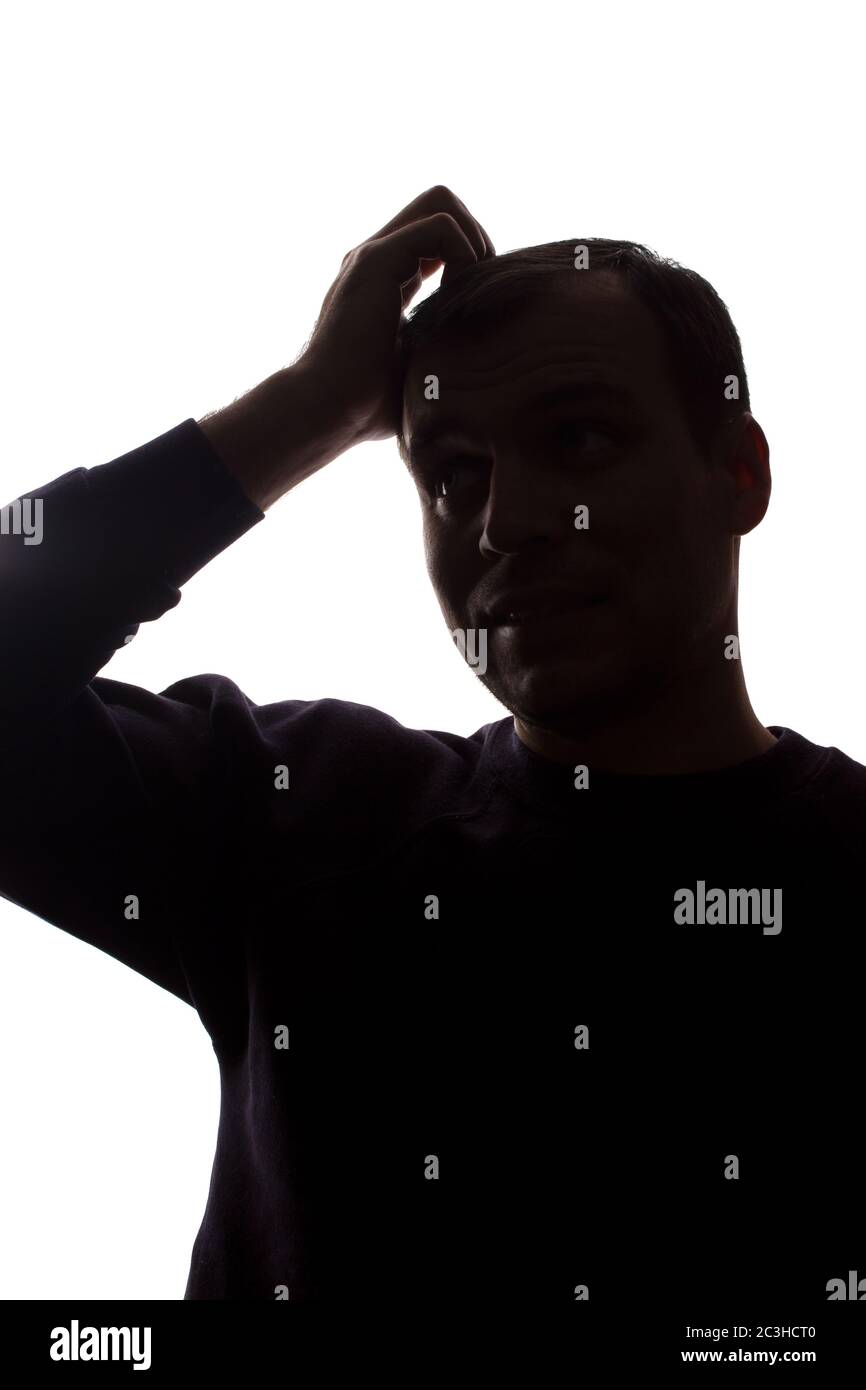 Porträt eines jungen Mannes, unrasiert, Vorderansicht - dunkel isoliert Silhouette Stockfoto