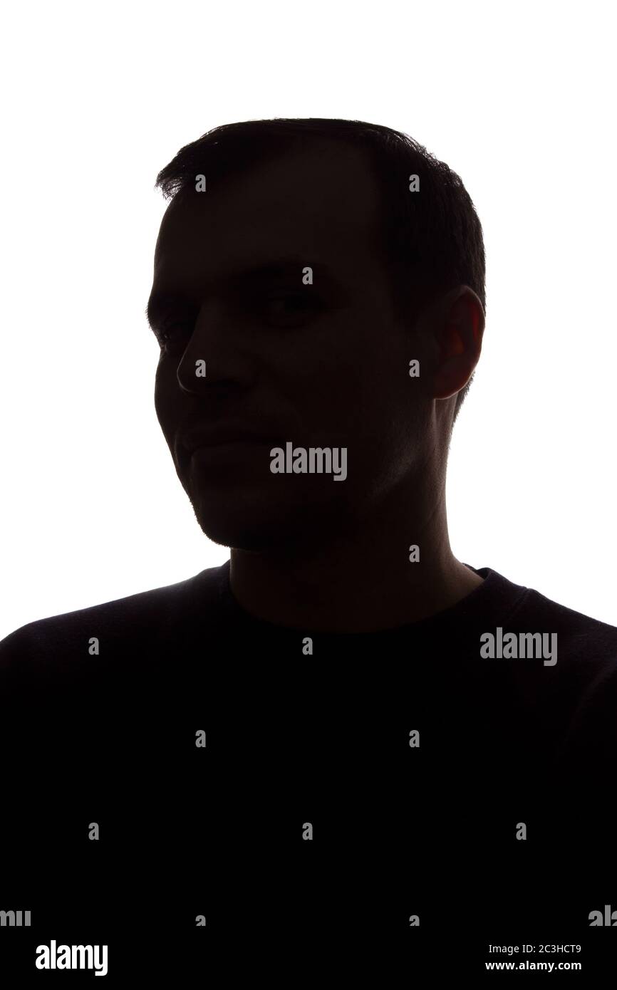 Porträt eines jungen Mannes, unrasiert, Seitenansicht - dunkel isoliert Silhouette Stockfoto