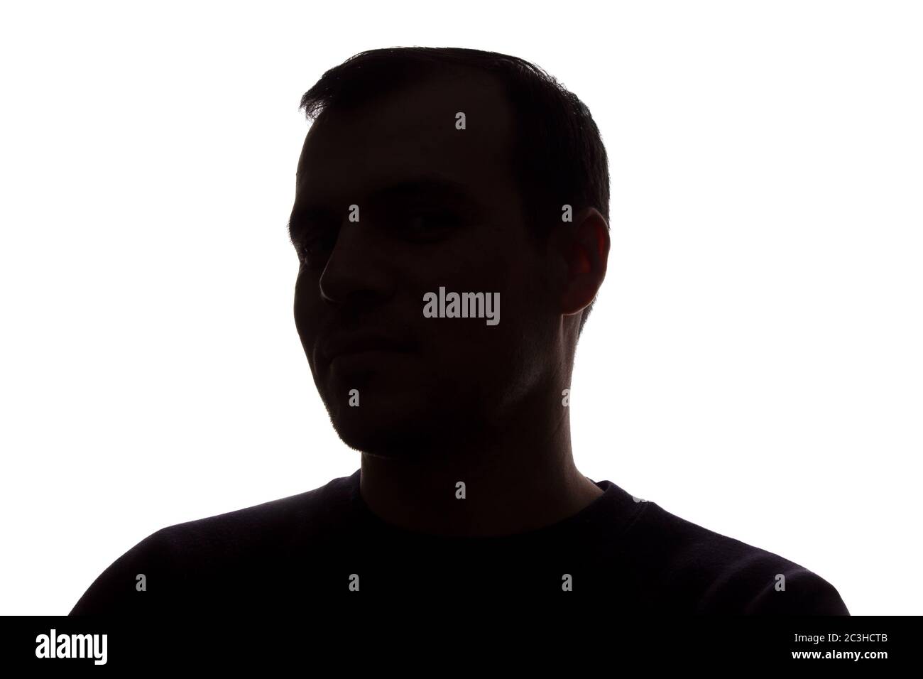 Porträt eines jungen Mannes, unrasiert, Seitenansicht - dunkel isoliert Silhouette Stockfoto