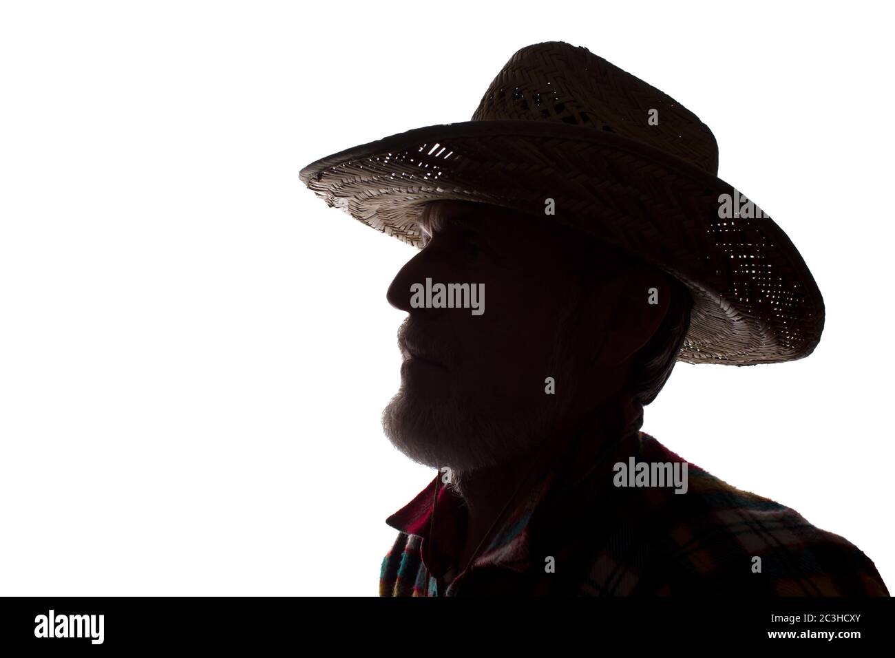 Porträt eines alten Mannes, in einem Cowboy-Hut, mit Bart, Seitenansicht - dunkel isoliert Silhouette Stockfoto